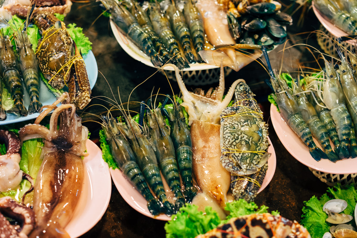 Fresh prawns, crab and squid arranged on plates